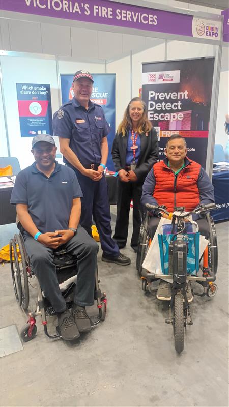 Angela Cook and Tim Marchinton at the Expo with two community members.